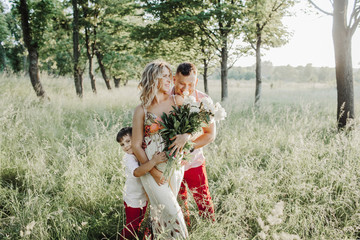 a father with a son hug a pregnant mother