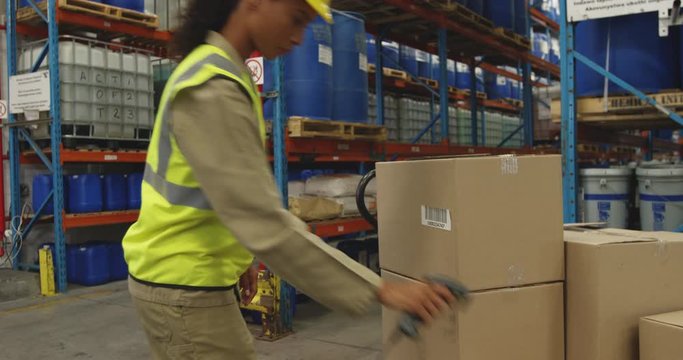 Young female worker using barcode scanner in a warehouse