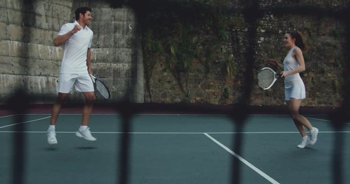 Woman and man playing tennis on a court