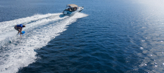 Speedboat with wakeboard rider on open sea