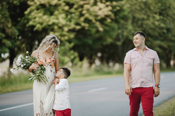 a little boy leans to his mom, and his dad looks at them