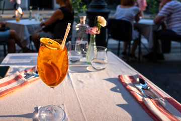 Glass of Aperol Spritz cocktail on the table in street restaurant, famous refreshing drink in sunny...