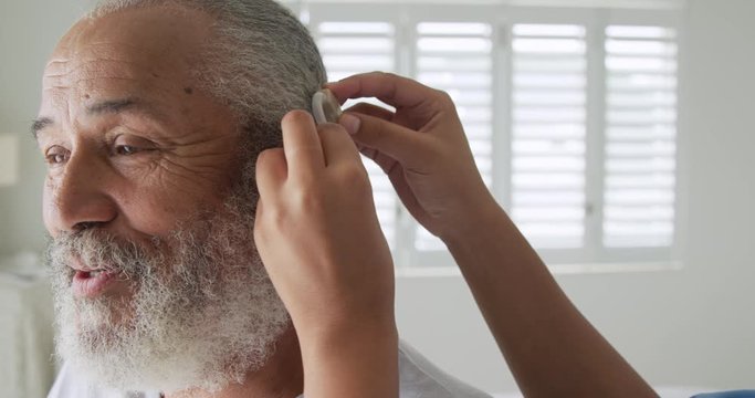 Mature mixed-race man with hearing aid