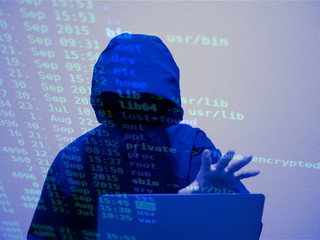 マウンテンパーカーのフードを被った人　ハッキング　サイバーセキュリティ