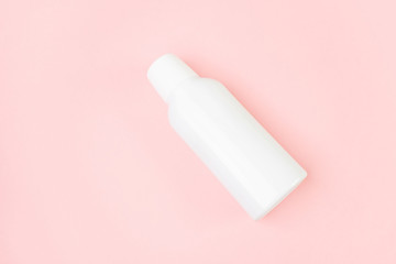 White bottle on a pastel pink background. Cosmetic bottle, images for mockup. Minimalism, place for text.