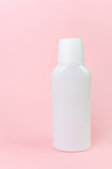 White bottle on a pastel pink background. Cosmetic bottle, images for mocap. Minimalism, place for text.