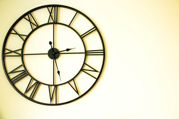 Old, vintage black clock on the bright background,  copy space 