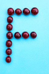Letter F fresh cherry alphabet blue color flat lay