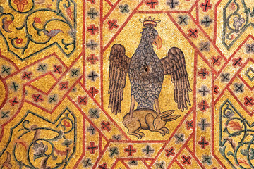 Fototapeta na wymiar Heraldic eagle and prey in ancient mosaics of Palermo