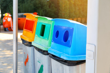 Tree dirty plastic garbage bins.