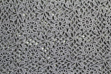 Knitted wool yarn floral pattern. Knitted gray background. Concept of craft and Hobbies.