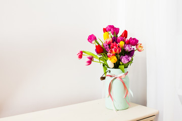 Bouquet of colorful tulips in white can
