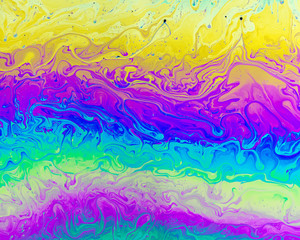 A creative abstract swirling liquid rainbow of colours that looks like watercolour paints or inks...