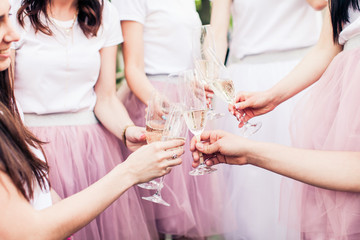 Hands of girls holding glasses with champagne