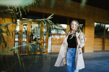 a stylish girl is walking across a street near woody building
