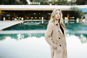 a girl stands near a pool in luxury hotel