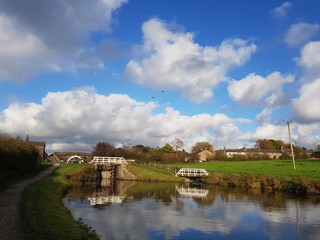 Fototapeta na wymiar White Bridges Blue Cloudy Skies Canal