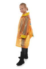 Full shot of a little blonde girl dressed in an orange nacre raincoat, black jeans and black high shammy boots. The raincoat with a print on the back side has a back section for a school bag 