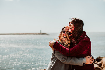 .Lesbian couple laughing together on their trip to Porto in Portugal. Walking along the coast on a windy afternoon. Inclusive love. Lifestyle. Travel photography