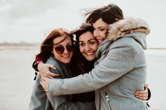 .Group of beautiful friends sharing laughs together on their trip to Porto in Portugal. Walking along the coast a windy afternoon. Lifestyle. Travel photography
