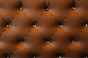 Many diamond on brown sofa texture background.