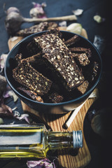 Rye bread croutons with seeds with olive oil and garlic. Vertical shot