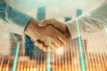 Double exposure of financial graph on cityscape background with two businessman handshake. Concept of stock market deal