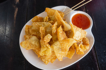 Close up deep fried pork wonton or giew moo with dipping sauce.