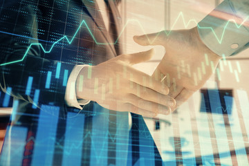 Multi exposure of financial graph on office background with two businessmen handshake. Concept of success in business