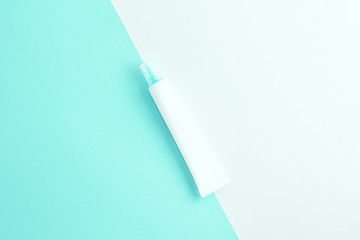 Cosmetics tube on light trendy mint and white background. Copy space. Flat lay.
