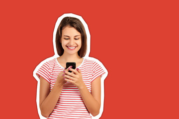 young woman in a red striped t-shirt looks at the phone and smiles, good news, joy. emotional girl Magazine collage style with trendy color background