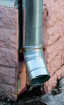 A new shiny drainpipe on a corner of a building 
