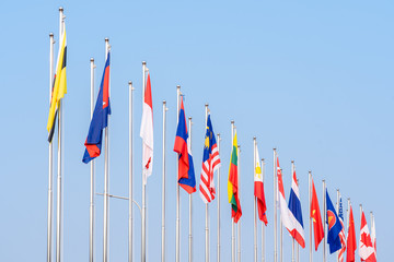 National flags different countries of Southeast Asia with blue sky background.