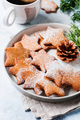 Homemade Christmas New year star shape gingerbread cookies in ceramic plate on old concrete gray vintage background. Top view with space.