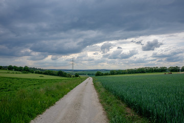 Feldweg unter schweren Juli-Wolken
