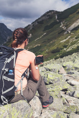 Active life of diabetics, woman hiking and checking glucose level with a remote sensor and mobile phone, sensor checkup glucose levels without blood