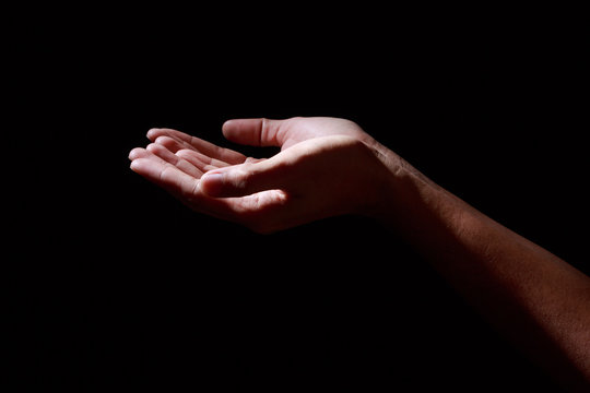Man hands in praying position low key image. High Contrast isolated on Black Background.