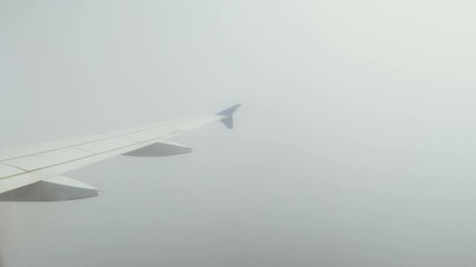 Aeroplane. View of airplane wing of aircraft flying above the clouds. 4K