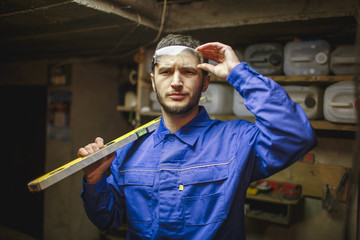 Portrait of a man working with a measuring instrument in his workshop.