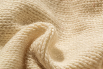 The closeup texture of cashmere things. Macro shot of knitted fabric from Lana Wool threads. Warm winter clothes. Background textile surface with copy space for text.