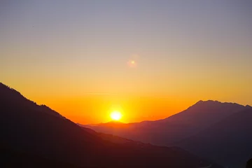 Fototapeten Sunset mountain valley hills landscape. Mountain valley sunset panorama. © Yulia
