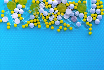 Ampoules for injection, pills and vitamins on a blue background. Medical concept.