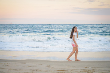 Playa y mar en la tarde con joven adolescente feliz disfrutando del paisaje. Viajes y turismo.