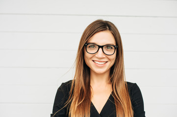 Close up portrait of beautiful young businesswoman wearing eyeglasses - obrazy, fototapety, plakaty