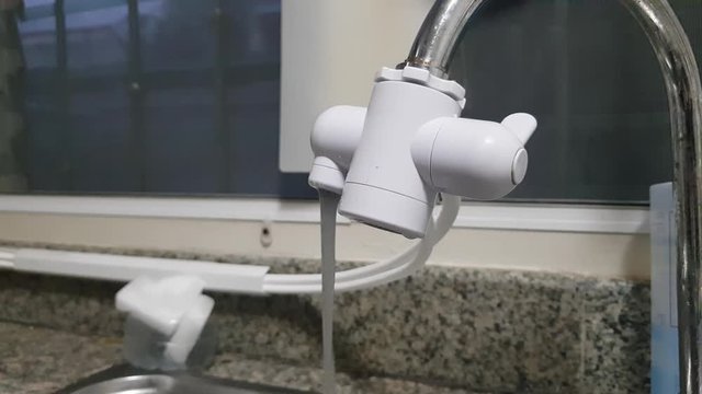 BANGKOK , THAILAND .September 16,2019 .AMWAY PRODUCT "eSpring" in a kitchen - Testing after changing filter - carbon water was pushed out before became mineral water  