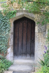Fototapeta na wymiar Medeval stone and wood doorway with ivy