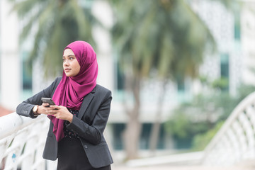 Beautiful Muslim Businesswoman with her Smartphone. Technology and communication concept.