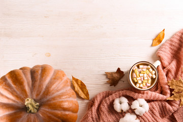 Thanksgiving background concept. Local produce pumpkin and autumn leaves with other decoration on textured table. Close up, copy space for text, top view, flat lay.