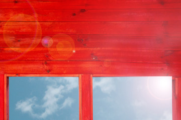 Red wood wall with windows to see blue sky and risen sun. Back light flash with flares goes from window edge. Mock-up with copy space. Linear pattern template for design and decoration purposes