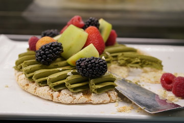 The beautiful and elegant delicious tempting green tea fruity pavlova plated on the white plate.